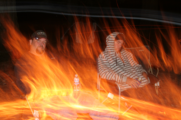 Father and son sitting by the campfire.